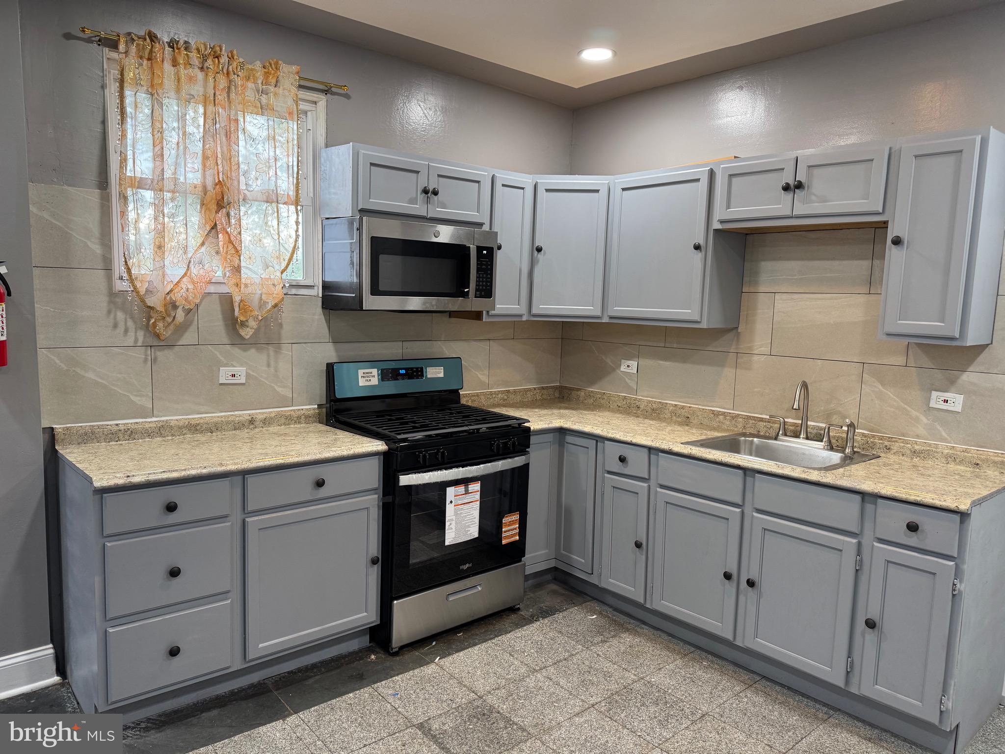 132 Walnut Street Colwyn, PA 19023 - Photo 6 of 43 a kitchen with sink cabinets and window