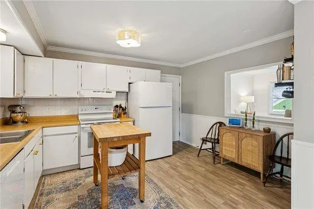 a room with a table chairs and a refrigerator