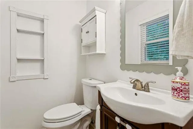 a bathroom with a sink a toilet and a mirror