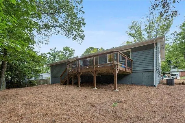 front view of a house with a yard and a large tree