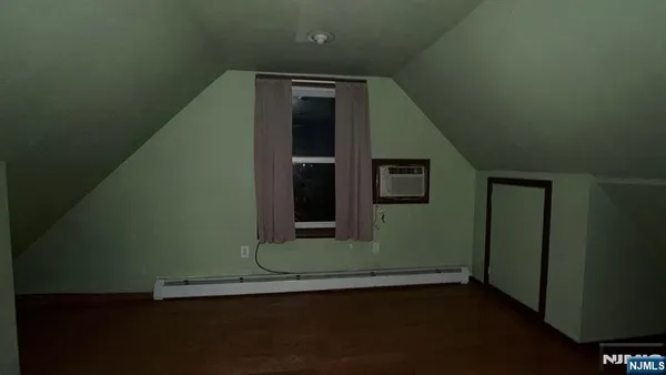 a view of a small space with wooden floor and a window