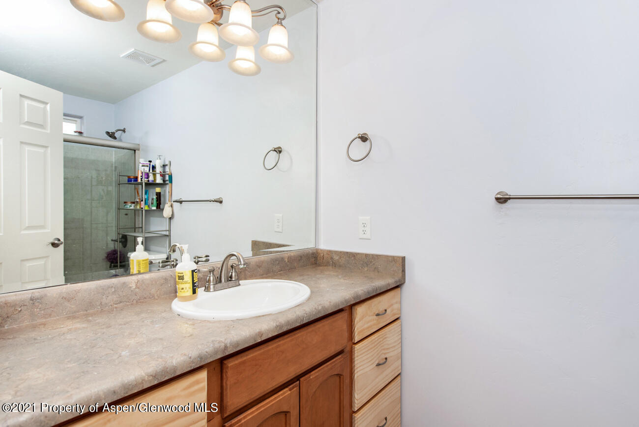 1784 Anvil View Avenue Rifle, CO 81650 - Photo 18 of 29 a bathroom with a granite countertop sink and a mirror
