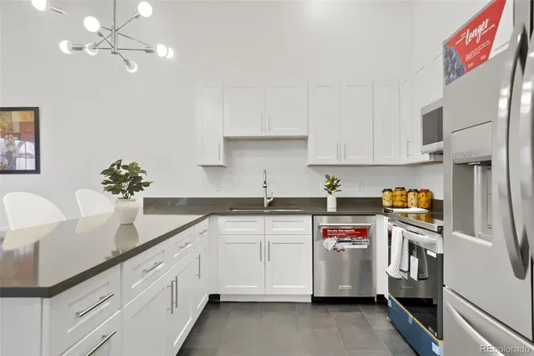 a kitchen with a sink dishwasher and white cabinets