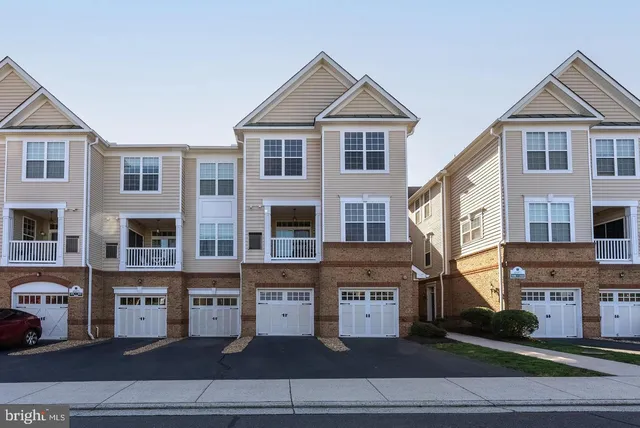 a view of a big house with a large windows and plants