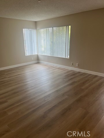 48 Clearbrook, Unit 56 Irvine, CA 92614 - Photo 4 of 6 an empty room with wooden floor and windows