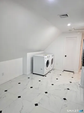 a utility room with cabinets washer and dryer