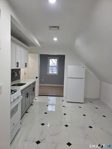 a large white kitchen with a sink