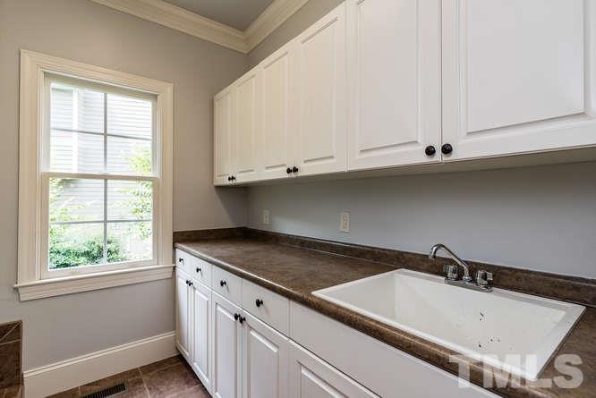 7026 Rippling Stone Lane Raleigh, NC 27612 - Photo 14 of 25 Large laundry room with tons of storage space and utility sink.