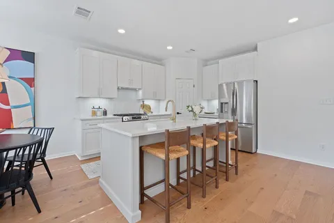a kitchen with a dining table chairs and refrigerator