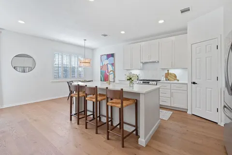 a kitchen with a dining table chairs and white cabinets