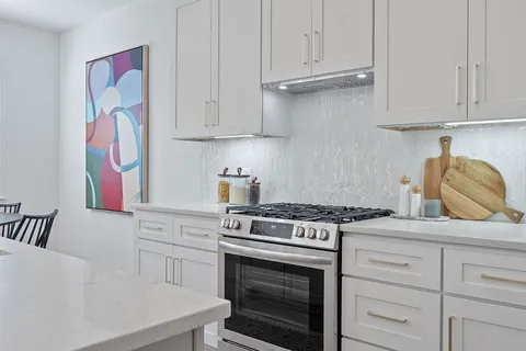 a kitchen with granite countertop white cabinets and white appliances