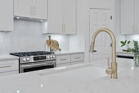 a kitchen with granite countertop a stove and a sink