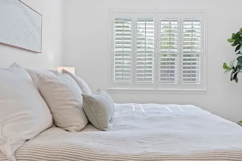 a view of a bedroom with a bed and a window