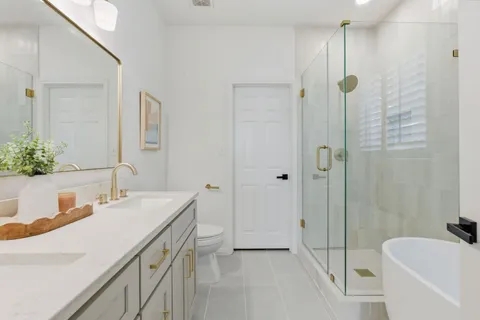 a bathroom with a tub sink toilet and shower