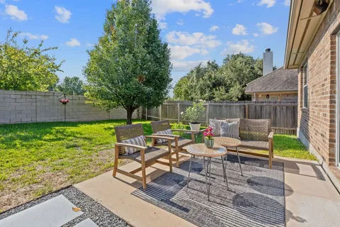 a view of a patio with table and chairs potted plants and a palm tree