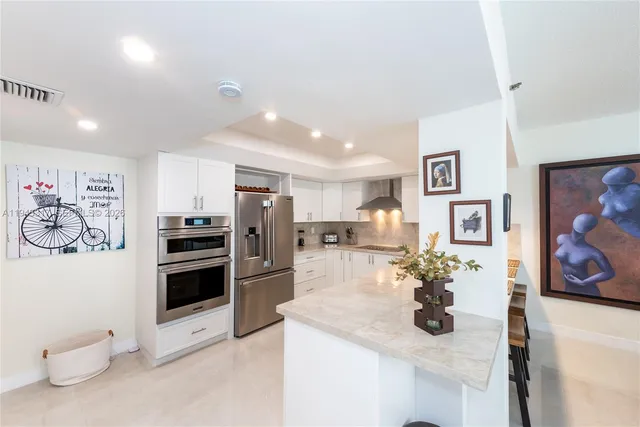 a kitchen with stainless steel appliances kitchen island granite countertop a sink and cabinets