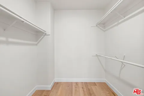 a view of walk in closet with empty racks