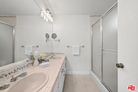 a bathroom with a sink mirror and a shower
