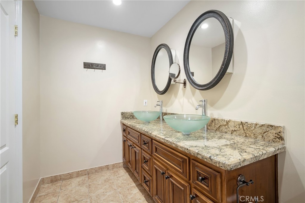 6541 Elmo Street Tujunga, CA 91042 - Photo 12 of 20 a bathroom with a granite countertop sink and a mirror