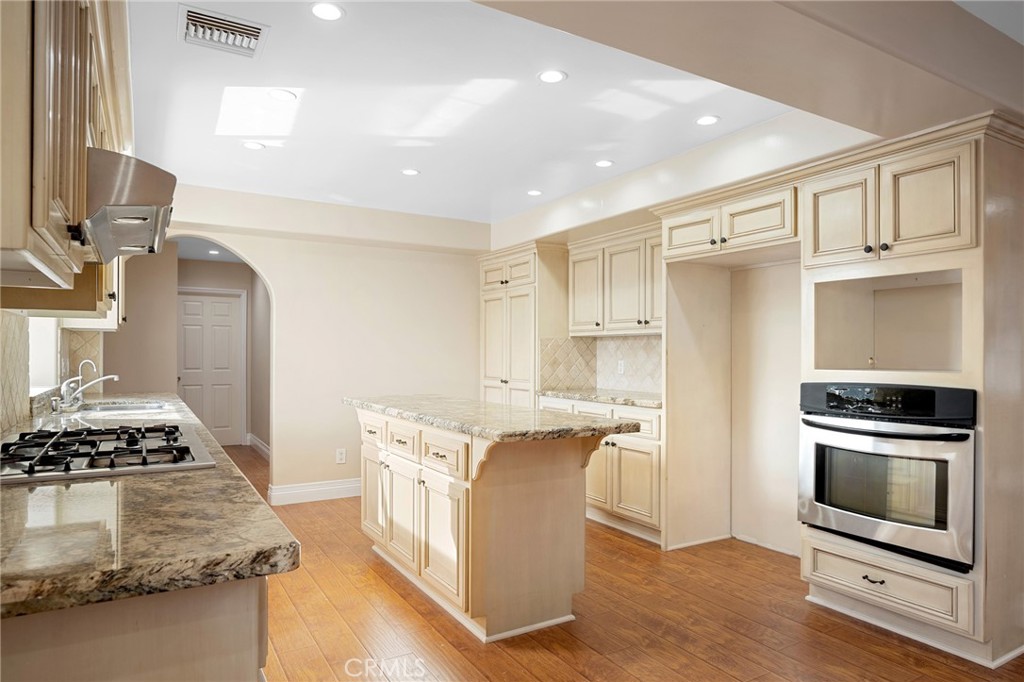 6541 Elmo Street Tujunga, CA 91042 - Photo 5 of 20 a kitchen with kitchen island granite countertop a stove and a sink