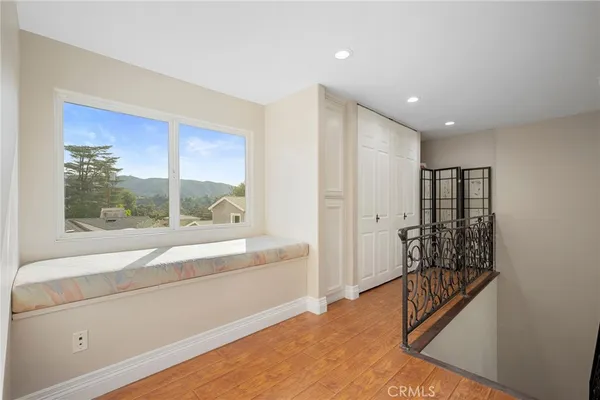 an empty room with wooden floor and window