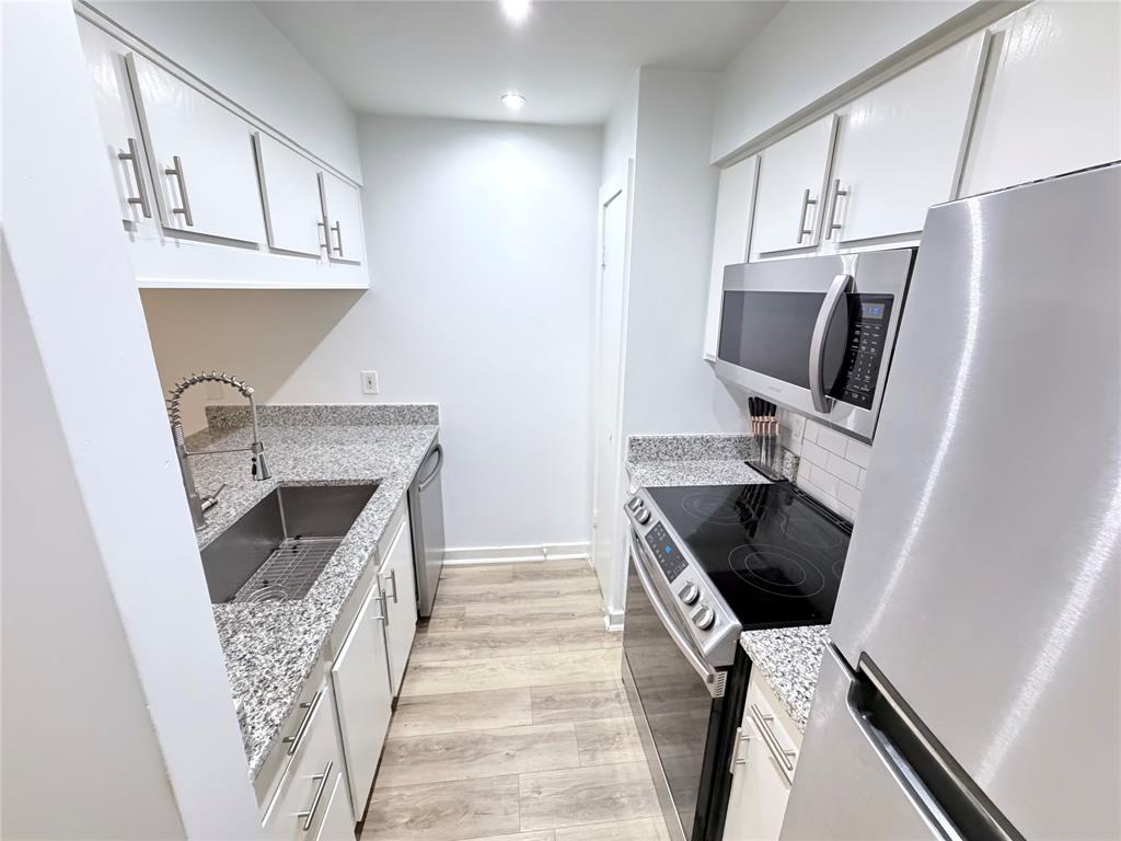 4837 Cedar Springs Road, Unit 110 Dallas, TX 75219 - Photo 13 of 21 a kitchen with stainless steel appliances a stove microwave and cabinets