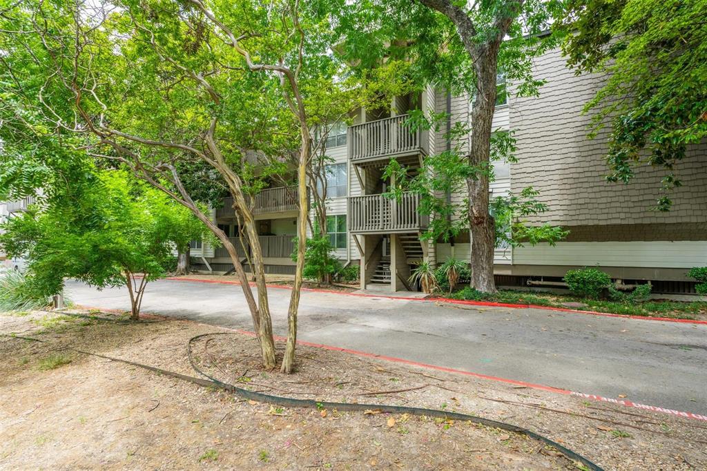 4837 Cedar Springs Road, Unit 110 Dallas, TX 75219 - Photo 20 of 21 a front view of a house with a yard and trees