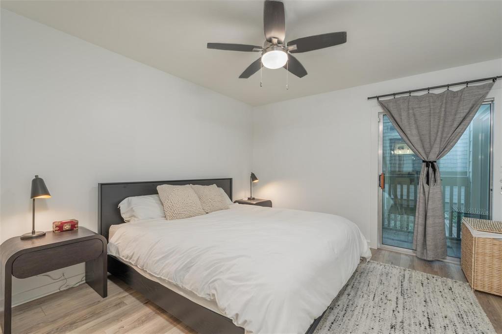 4837 Cedar Springs Road, Unit 110 Dallas, TX 75219 - Photo 9 of 21 a bedroom with a large bed and a chandelier
