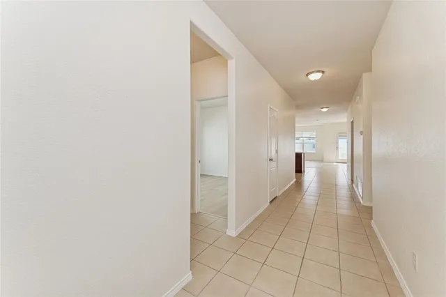 a view of an empty room with kitchen and kitchen view
