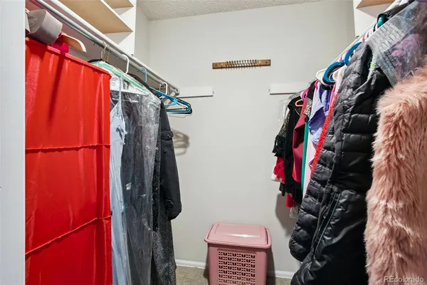 a view of walk in closet with clothes and shoes