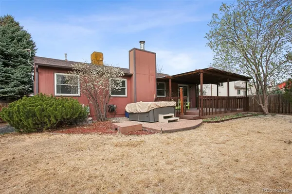 a porch with wooden floor outdoor seating and yard in the back