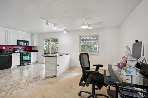 a view of a workspace with furniture and a kitchen