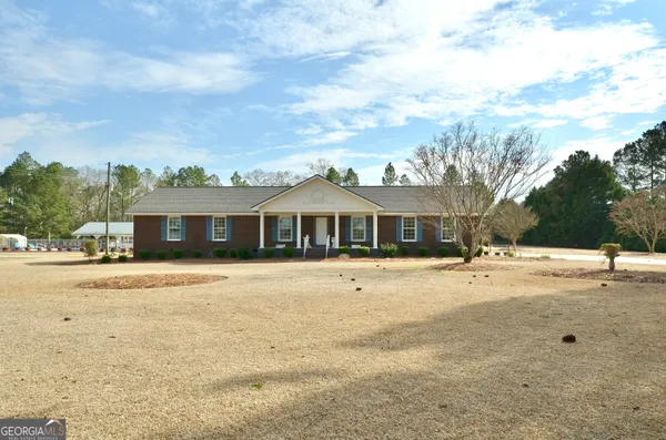 a front view of a house with a yard and trees