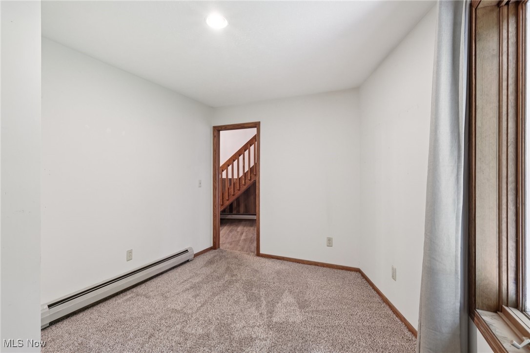 5643 Chapin Road Madison, OH 44057 - Photo 24 of 50 Carpeted spare room with baseboard heating, stairway, and a baseboard radiator