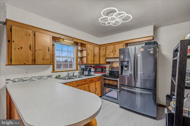 a kitchen with stainless steel appliances granite countertop a refrigerator a stove and a sink