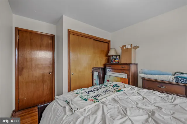 a bedroom with a bed and a flat tv screen on dresser