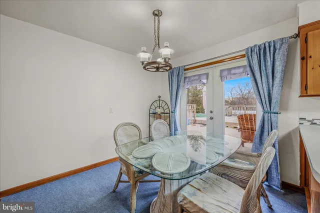 a dining room with furniture a chandelier and wooden floor