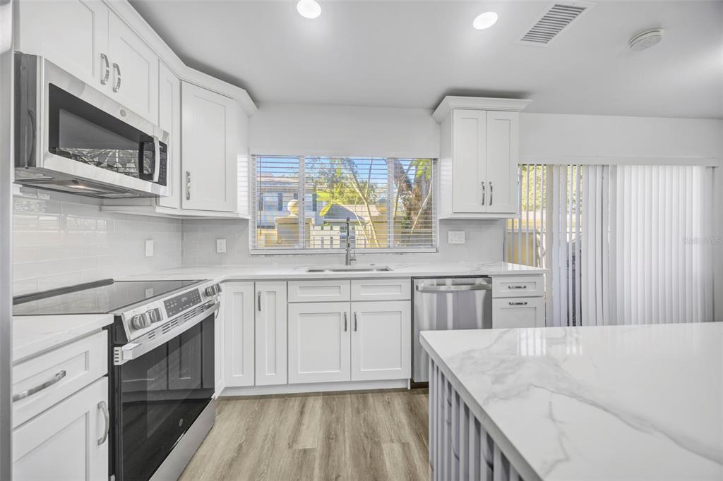 11728 Raintree Drive Temple Terrace, FL 33617 - Photo 11 of 41 a kitchen with stainless steel appliances granite countertop a stove a sink and a microwave