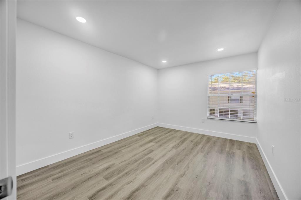 11728 Raintree Drive Temple Terrace, FL 33617 - Photo 32 of 41 an empty room with wooden floor and windows