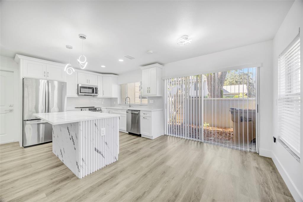 11728 Raintree Drive Temple Terrace, FL 33617 - Photo 10 of 41 a kitchen with white cabinets and stainless steel appliances