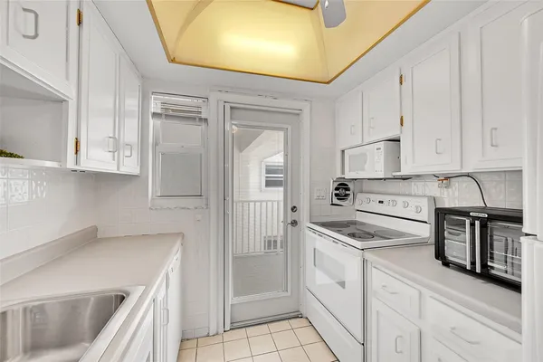 a kitchen with granite countertop white cabinets and white appliances
