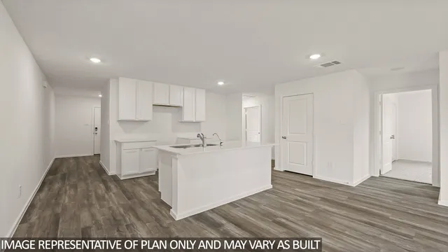 a kitchen with cabinets and wooden floor