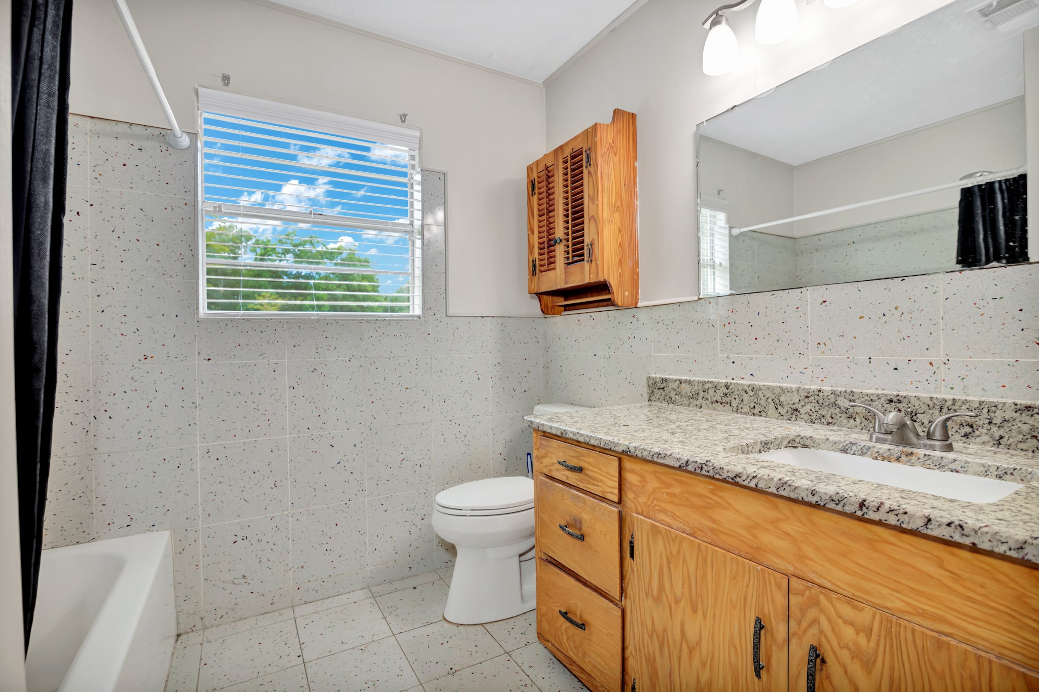 10863 Autumn Lane Cleveland, TX 77328 - Photo 20 of 24 a bathroom with a granite countertop toilet sink and mirror