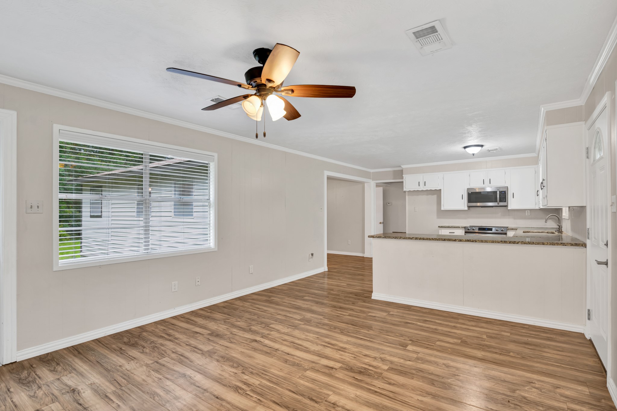 10863 Autumn Lane Cleveland, TX 77328 - Photo 5 of 24 a view of kitchen with wooden floor a ceiling fan and windows