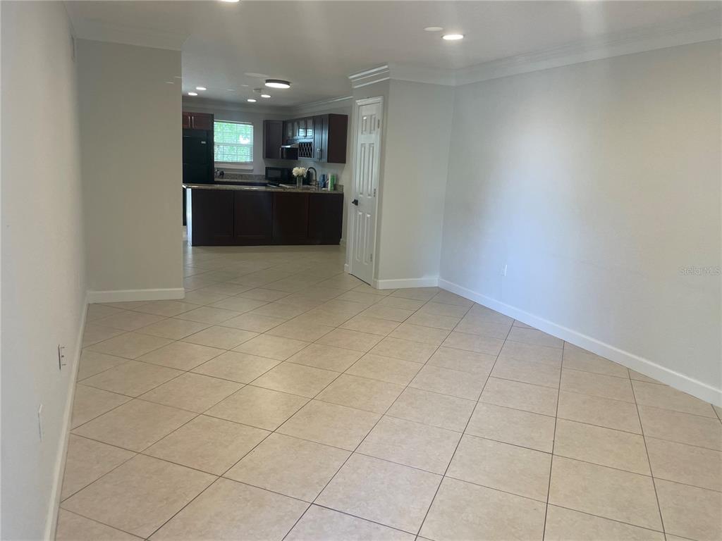 2500 Lee Road, Unit 202 Winter Park, FL 32789 - Photo 26 of 52 an empty room with kitchen and chandelier fan