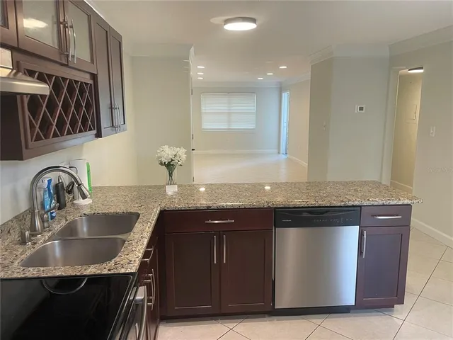 a kitchen with stainless steel appliances granite countertop a sink a stove a refrigerator and cabinets