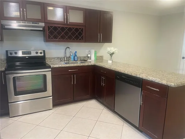 a kitchen with stainless steel appliances granite countertop a stove a sink and a microwave