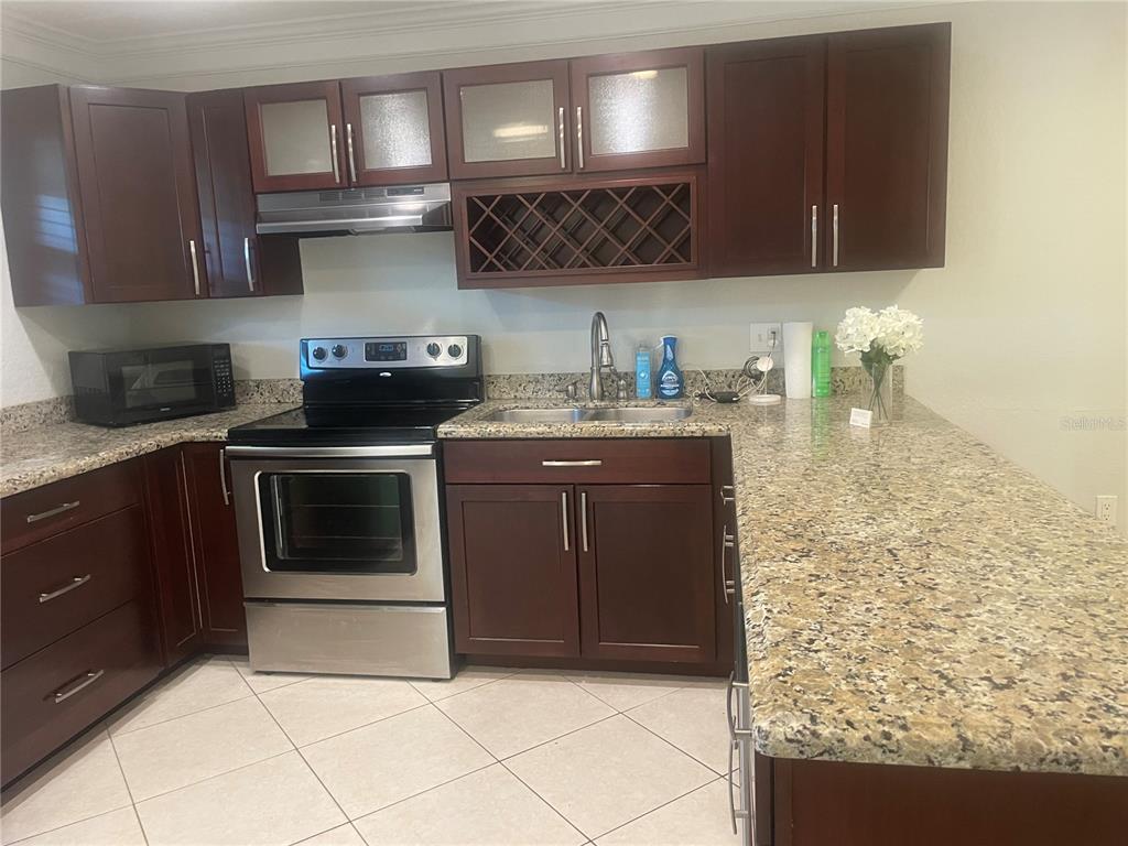 2500 Lee Road, Unit 202 Winter Park, FL 32789 - Photo 6 of 39 a kitchen with stainless steel appliances granite countertop a stove a sink and a microwave
