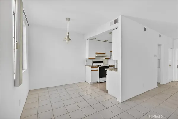 a kitchen with granite countertop a stove a sink and a refrigerator