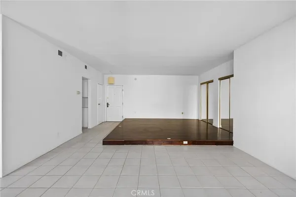 a kitchen with a refrigerator and white cabinets